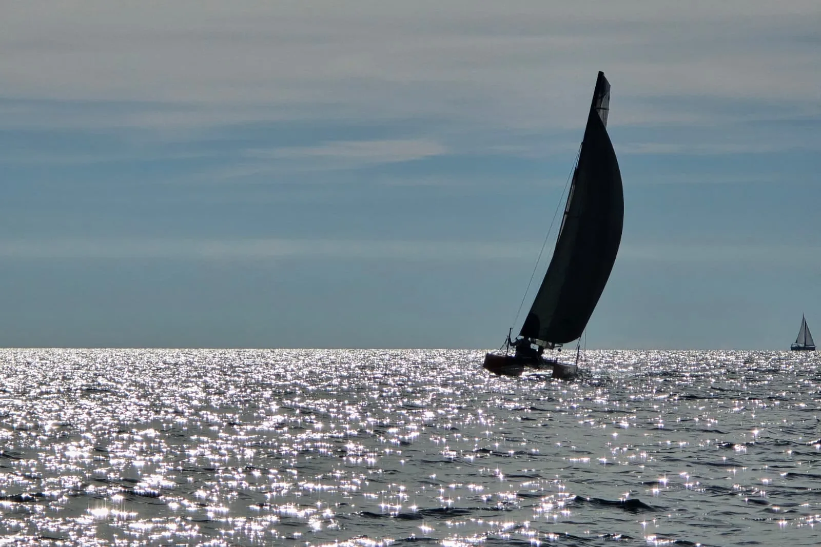 Silueta Hobie Wild Cata pod jedrima na svjetlucavom Jadranu u zlatnom satu.